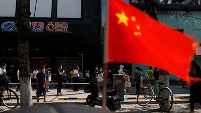 China-Taiwan Conflict: A China's flag flutters near people lining up to get tested at a makeshift nucleic acid testing site.&nbsp; (Reuters)