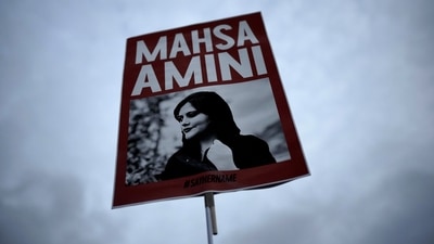 Iran Anti-Hijab Protests: A woman holds a placard with a picture of Iranian woman Mahsa Amini during a protest against her death. (AP) Iran Anti-Hijab Protests: A woman holds a placard with a picture of Iranian woman Mahsa Amini during a protest against her death. (AP)