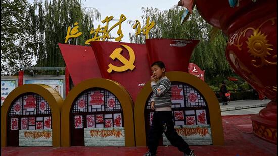 A boy plays next to a festive installation with party emblem at a citizen square near Baota mountain in Yan'an city, in China’s northwest Shaanxi province on Saturday, one day ahead of the 20th Communist Party Congress. (AFP)
