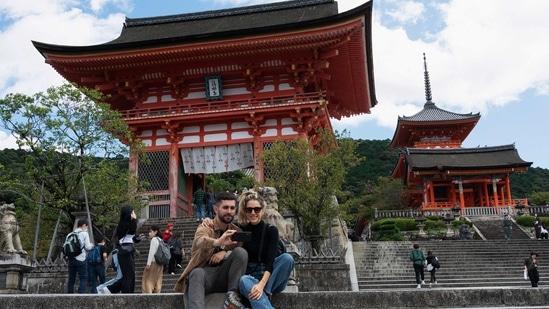 A man and woman pose for a selfie by the entrance of Kiyomizu-dera temple in Kyoto. Japan reopened its doors to tourists on October 11 after two-and-a-half years of tough Covid-19 restrictions, with officials hoping an influx of travellers enticed by a weak yen will boost the economy.&nbsp;(Photo by Fred MERY / AFP)