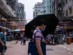 Covid In Hong Kong: A woman uses an umbrella to shield herself from the sun in Hong Kong.