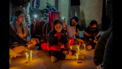 Kashmiri Pandits sit on a road during a candlelight protest against the killing of Puran Krishan Bhat in Srinagar on Sunday. (AP)