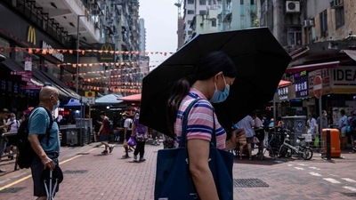 Covid In Hong Kong: A woman uses an umbrella to shield herself from the sun in Hong Kong. (AFP) Covid In Hong Kong: A woman uses an umbrella to shield herself from the sun in Hong Kong. (AFP)
