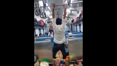 In a crowded train, a man is observed navigating by clinging to the railings.. (Twitter/@GaurangBhardwa1) In a crowded train, a man is observed navigating by clinging to the railings.. (Twitter/@GaurangBhardwa1)