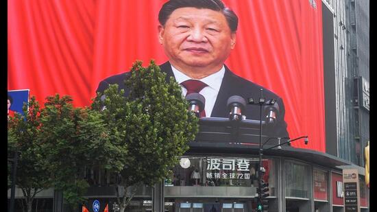 People watch an outdoor screen showing the live speech of Chinese President Xi Jinping, October 16, 2022 (AFP)