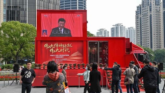 People watch a screen showing China's President Xi Jinping speaking during the opening session of the Chinese Communist Party's Congress in Shanghai.(AFP)