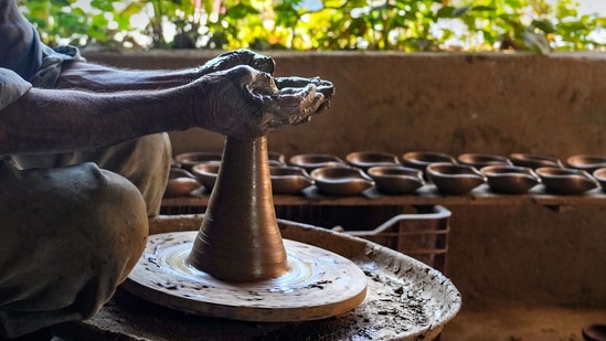 Srinagar: Father of potter Mohammad Umar Kumar moulds an earthen lamp on a wheel, ahead of Diwali festival, at his workshop at Eishbar, Nishat in Srinagar, Saturday,&nbsp;(PTI Photo/S. Irfan)