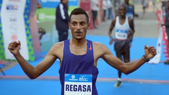 New Delhi: Ethiopia's Chala Regasa celebrates after crossing the finish line to retain his men's elite title at the Vedanta Delhi Half Marathon 2022, at Jawaharlal Nehru Stadium, in New Delhi.(PTI)