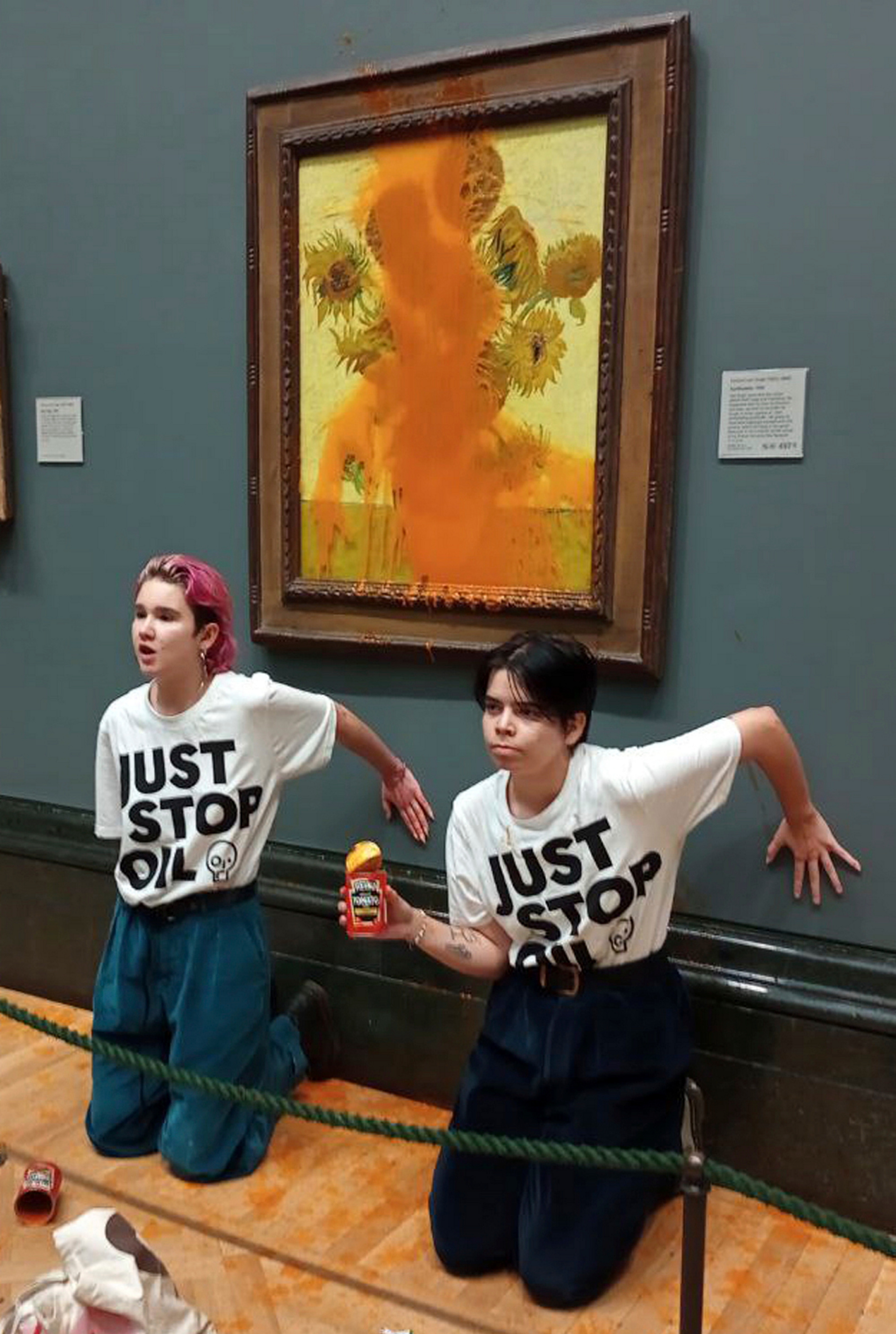 Handout photo issued by Just Stop Oil of two protesters who have thrown tinned soup at Vincent Van Gogh's famous 1888 work Sunflowers at the National Gallery in London AP/PTI (AP)