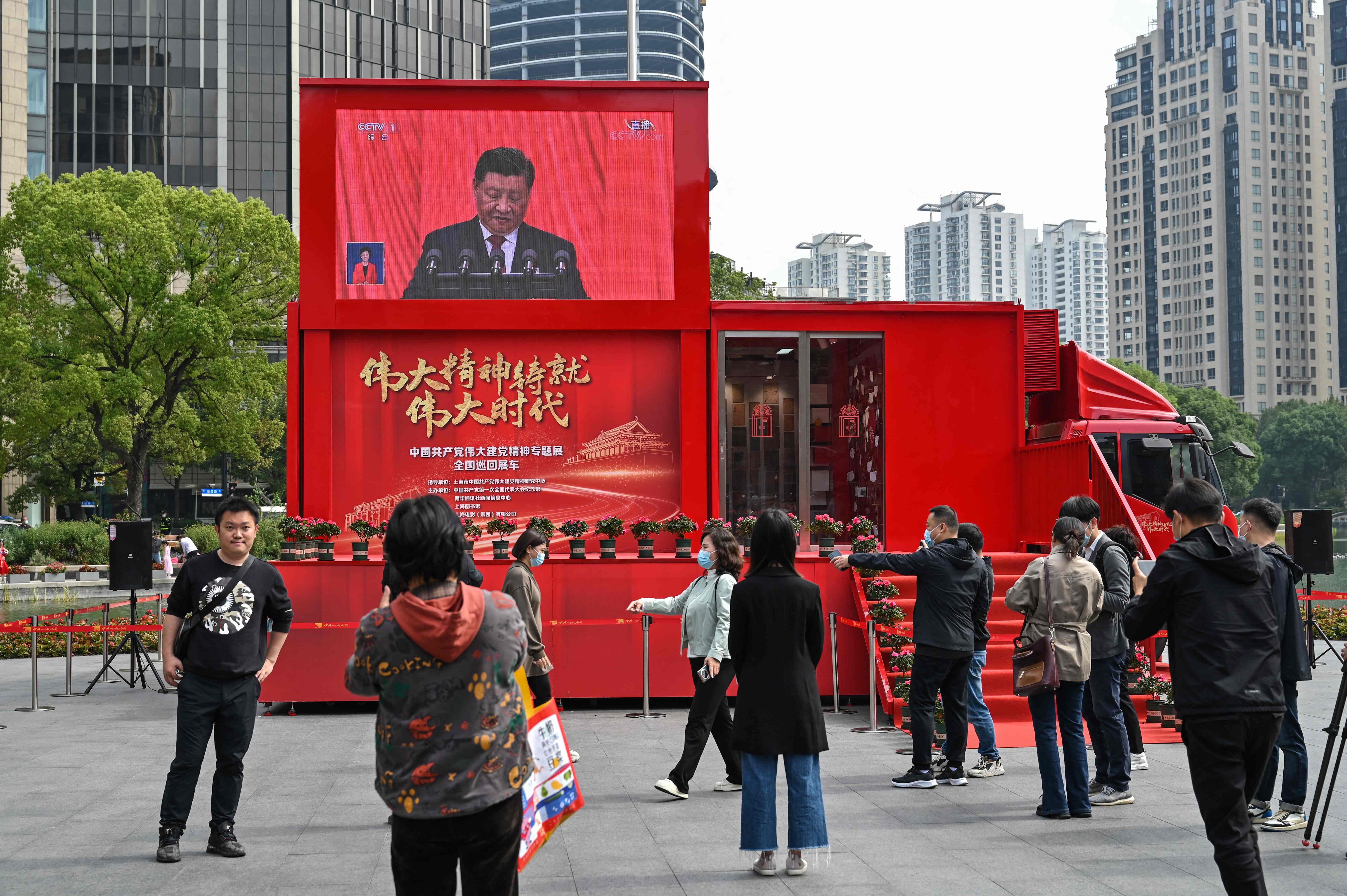 People watch a screen showing China's President Xi Jinping speaking during the opening session of the Chinese Communist Party's Congress in Shanghai.&nbsp; (AFP)