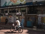 Covid In China: A cyclist rides past shuttered stores.