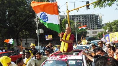 New Delhi, Oct 17 (ANI): Delhi Deputy Chief Minister and Aam Admi Party (AAP) leader Manish Sisodia waves the National flag as he holds a roadshow on his way to the Central Bureau of Investigation (CBI) headquarters after being summoned for questioning in the excise policy case, in New Delhi on Monday. (ANI Photo) (ANI)