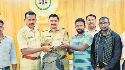 Police officials hand over the bag with cash to the owner. (HT Photo) Police officials hand over the bag with cash to the owner. (HT Photo)