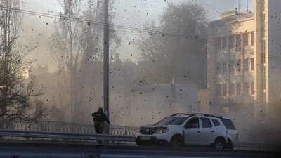 Russia-Ukraine War: A police officer watches stone and earth debris flying through the air as Russian kamikaze drones hit the centre of the capital Kyiv. (AP)