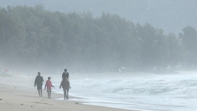 Thailand Weather: A tourist rides a horse in rainy monsoon weather at Bangtao beach in Phuket, Thailand. (Reuters)