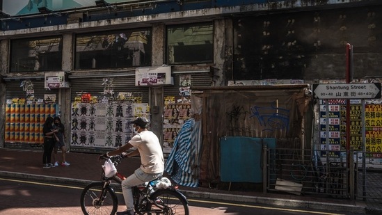 Covid In China: A cyclist rides past shuttered stores.(Bloomberg) Covid In China: A cyclist rides past shuttered stores.(Bloomberg)