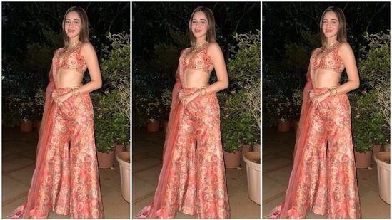 Ananya Panday wore peach-coloured bustier and palazzo pants adorned in floral motif embroidery done in various shades of coral and pink hues. While the bustier features broad straps, a plunging neckline, cut-outs on the back, mirror embellishments, cropped midriff-baring hem and sequin embellishment, the palazzo pants come with a high-rise waist, flared silhouette and sequin work.(Instagram/@ananyapanday)