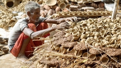 A potter arranges earthen lamps ahead of Diwali, in Patna, Bihar ahead of Diwali. (HT Photo/Santosh Kumar)