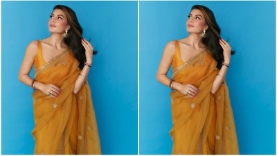 Jacqueline paired the drape with a matching yellow silk blouse featuring a wide U neckline, plunging back, broad straps, and back hook closures. (Instagram) Jacqueline paired the drape with a matching yellow silk blouse featuring a wide U neckline, plunging back, broad straps, and back hook closures. (Instagram)