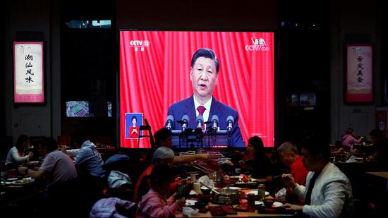 Diners eat in front of a screen showing live broadcast of Chinese President Xi Jinping's speech at the opening ceremony of the 20th National Congress of the Communist Party of China, inside a restaurant in Beijing, China. (REUTERS)