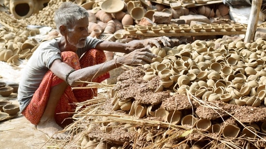 A potter arranges earthen lamps ahead of Diwali, in Patna, Bihar ahead of Diwali.(HT Photo/Santosh Kumar)