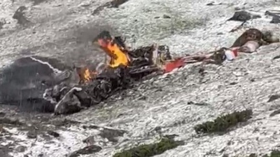 In images accessed by Hindustan Times, the crushed chopper can be seen burning in flames with parts of it scattered all over the site. In images accessed by Hindustan Times, the crushed chopper can be seen burning in flames with parts of it scattered all over the site.