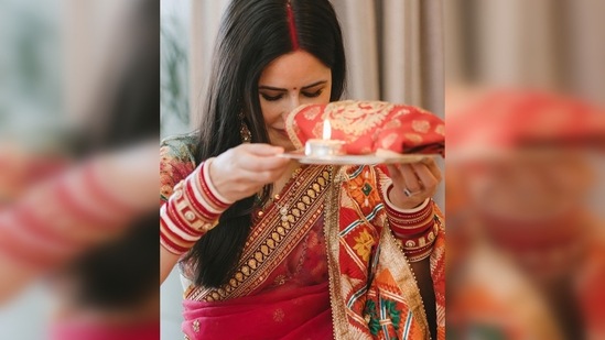 Katrina Kaif wore a beautiful red saree with a contrasting pastel green blouse while Vicky Kaushal complemented his wife in a beige kurta pyjama.(Instagram/@katrinakaif)