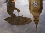 UK Cost Of Living Crisis: A woman with an umbrella and the Elizabeth Tower also known as Big Ben are reflected in a puddle in London. UK Cost Of Living Crisis: A woman with an umbrella and the Elizabeth Tower also known as Big Ben are reflected in a puddle in London.