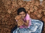 A girl holds diyas in her hands and beams with excitement to welcome the festival of lights. (Deepak Gupta/ HT Photo)