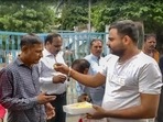 A man offers sweets to people convicted for rape and murder in the Bilkis Bano case of the 2002 post-Godhra riots, after they came out of the Godhra sub-jail.