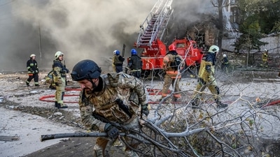 Russia-Ukraine War: Firefighters help a local woman evacuate from a residential building destroyed by a Russian drone strike in Kyiv, Ukraine. (Reuters)