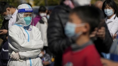 Covid In Beijing: A worker in protective suit stands watch as masked residents wait in line to get their routine in Beijing. (AP) Covid In Beijing: A worker in protective suit stands watch as masked residents wait in line to get their routine in Beijing. (AP)