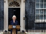 British Prime Minister Liz Truss announces her resignation, as her husband Hugh O'Leary stands nearby, outside Number 10 Downing Street, London.