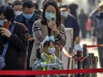 Covid In China: People wearing face masks stand in line for COVID-19 tests at a coronavirus testing site in Beijing.