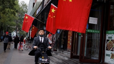 Covid In China: Chinese national flags fly in a street as the 20th National Congress of the Communist Party of China continues in Beijing. (Reuters)