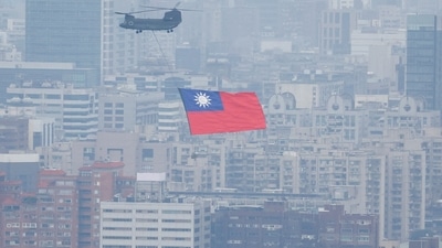 China-Taiwan Conflict: A Chinook helicopter carrying a Taiwan flag flies over the city during the country's National Day celebration in Taipei, Taiwan. (Reuters)