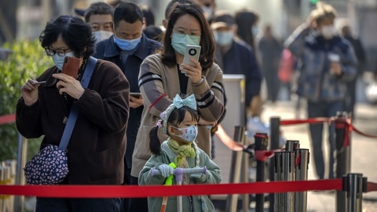 Covid In China: People wearing face masks stand in line for COVID-19 tests at a coronavirus testing site in Beijing.(AP)