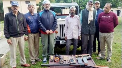 Forest department officials with the arrested poachers in the Corbett Tiger Reserve. (Sourced Photo) Forest department officials with the arrested poachers in the Corbett Tiger Reserve. (Sourced Photo)