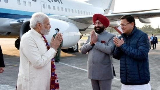 Prime Minister Narendra Modi being received by Uttarakhand chief minister Pushkar Singh Dhami and Governor Lt Gen (Retd) Gurmeet Singh at Jolly Grant Airport, in Dehradun.(@pushkardhami/ Twitter)
