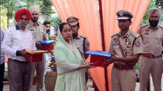 CP Ludhiana Kaustubh Sharma honouring the family of cops who sacrificed their lives while on duty, on the Police Commemoration Day at Police Lines in Ludhiana. (Gurpreet Singh/HT)