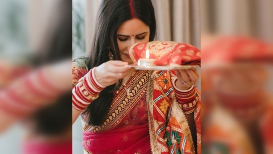 Katrina Kaif wore a beautiful red saree with a contrasting pastel green blouse while Vicky Kaushal complemented his wife in a beige kurta pyjama.(Instagram/@katrinakaif)
