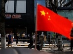 China’s Communist Party: A China's flag flutters near people lining up to get tested at a makeshift nucleic acid testing site. (File image)