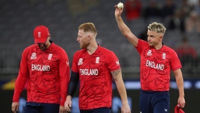 England bowler Sam Curran holds the ball aloft as he gestures to the crowd (AP)
