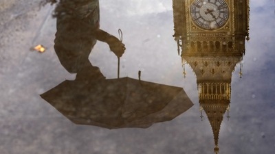 Britain Power Cuts: A woman with an umbrella and the Elizabeth Tower also known as Big Ben are reflected in a puddle in London. (AP) Britain Power Cuts: A woman with an umbrella and the Elizabeth Tower also known as Big Ben are reflected in a puddle in London. (AP)
