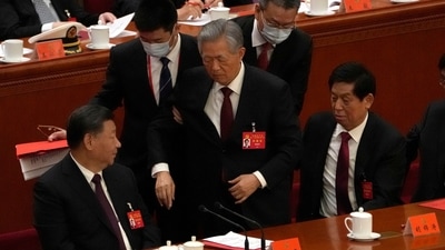 Former Chinese president Hu Jintao, center, is escorted out of the closing ceremony of a congress of the ruling Communist Party on Saturday. (AP) Former Chinese president Hu Jintao, center, is escorted out of the closing ceremony of a congress of the ruling Communist Party on Saturday. (AP)