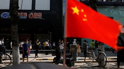 China’s Communist Party: A China's flag flutters near people lining up to get tested at a makeshift nucleic acid testing site. (File image) (Reuters)