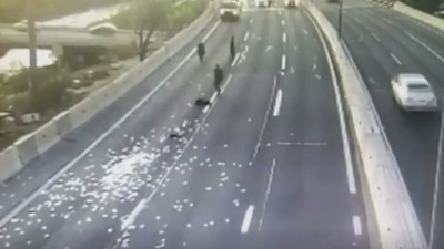 Screengrab of the video showing money money fallen on the highway in Chile. (Skynews) Screengrab of the video showing money money fallen on the highway in Chile. (Skynews)