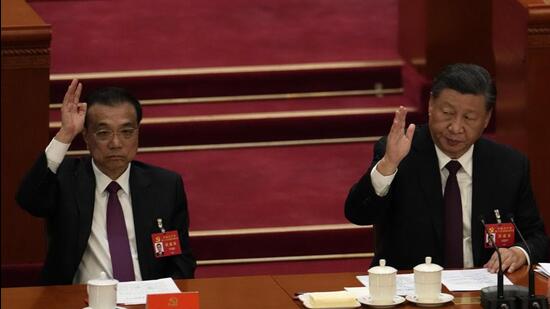 President Xi Jinping (right) looks over as Premier Li Keqiang raises his hand to vote at the closing ceremony of the 20th National Congress of China’s ruling Communist Party at the Great Hall of the People in Beijing, on Saturday. (AP)
