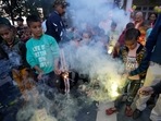 Children watch firecrackers being lit on the eve of Diwali in Jammu on Sunday, 