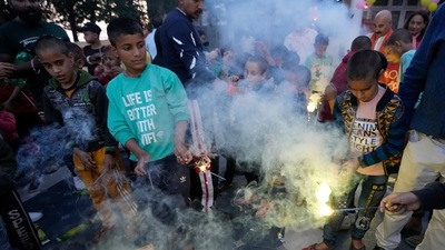Children watch firecrackers being lit on the eve of Diwali in Jammu on Sunday, (AP) Children watch firecrackers being lit on the eve of Diwali in Jammu on Sunday, (AP)